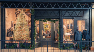 A store front with christmas tree and lights.