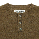 Close-up of the Tom Beckbe Albemarle Henley Sweater in brown wool with three buttons and a label at the neckline.