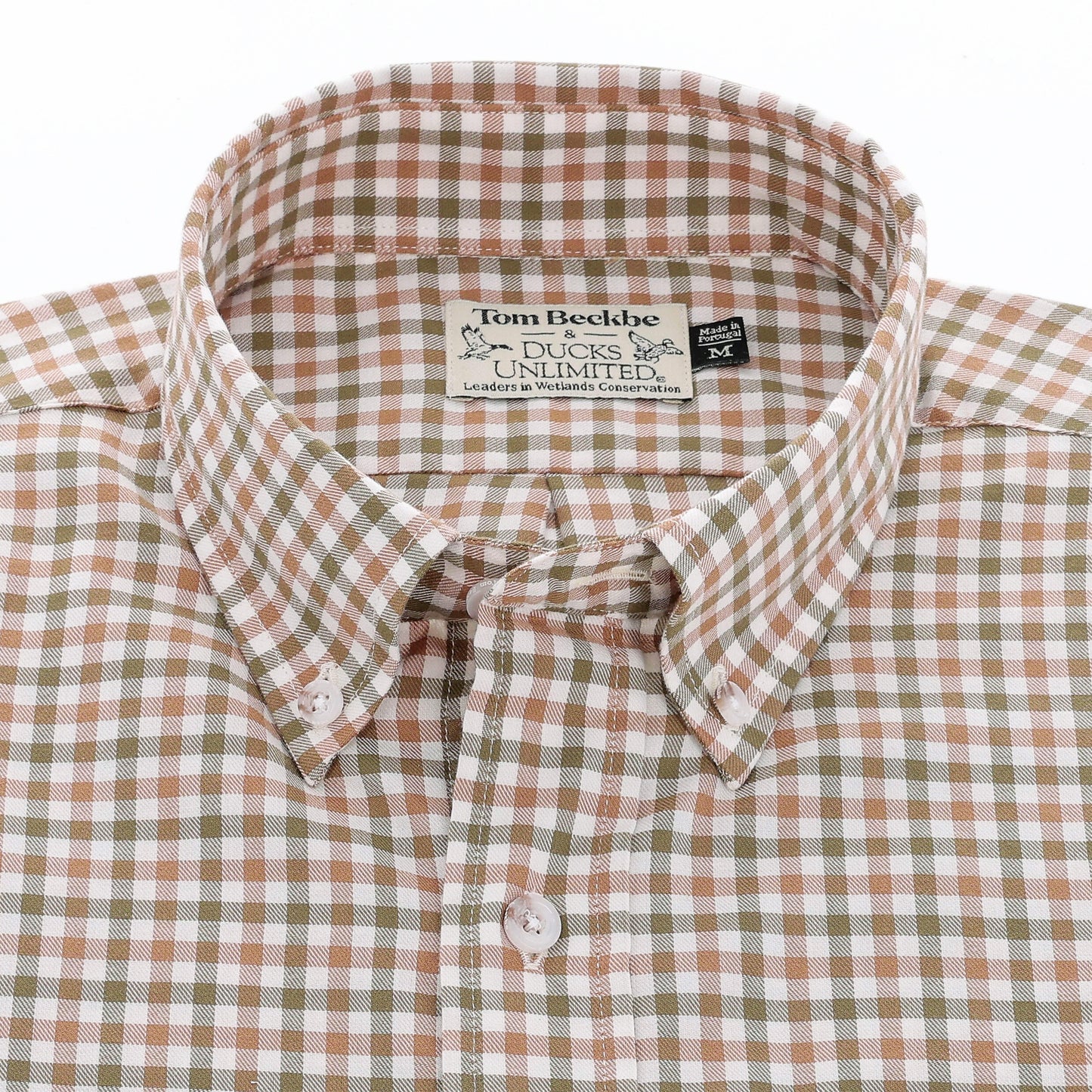 A brown, tan, and white plaid button-down shirt with a visible collar and brand label inside the neck.