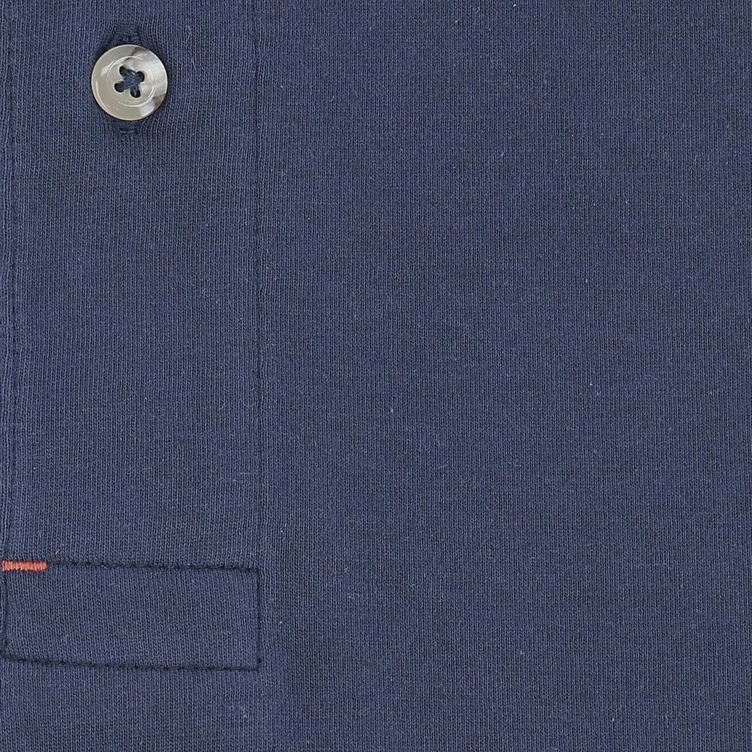 Close-up of the Tom Beckbe Benton Polo Shirt in navy, highlighting the button, seam, and red stitching detail.