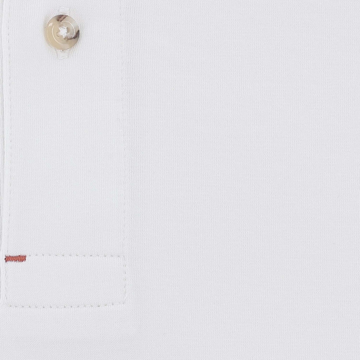 Close-up of the Benton Polo Shirt by Tom Beckbe: classic fit, white, beige button, stitched square, red thread accent.
