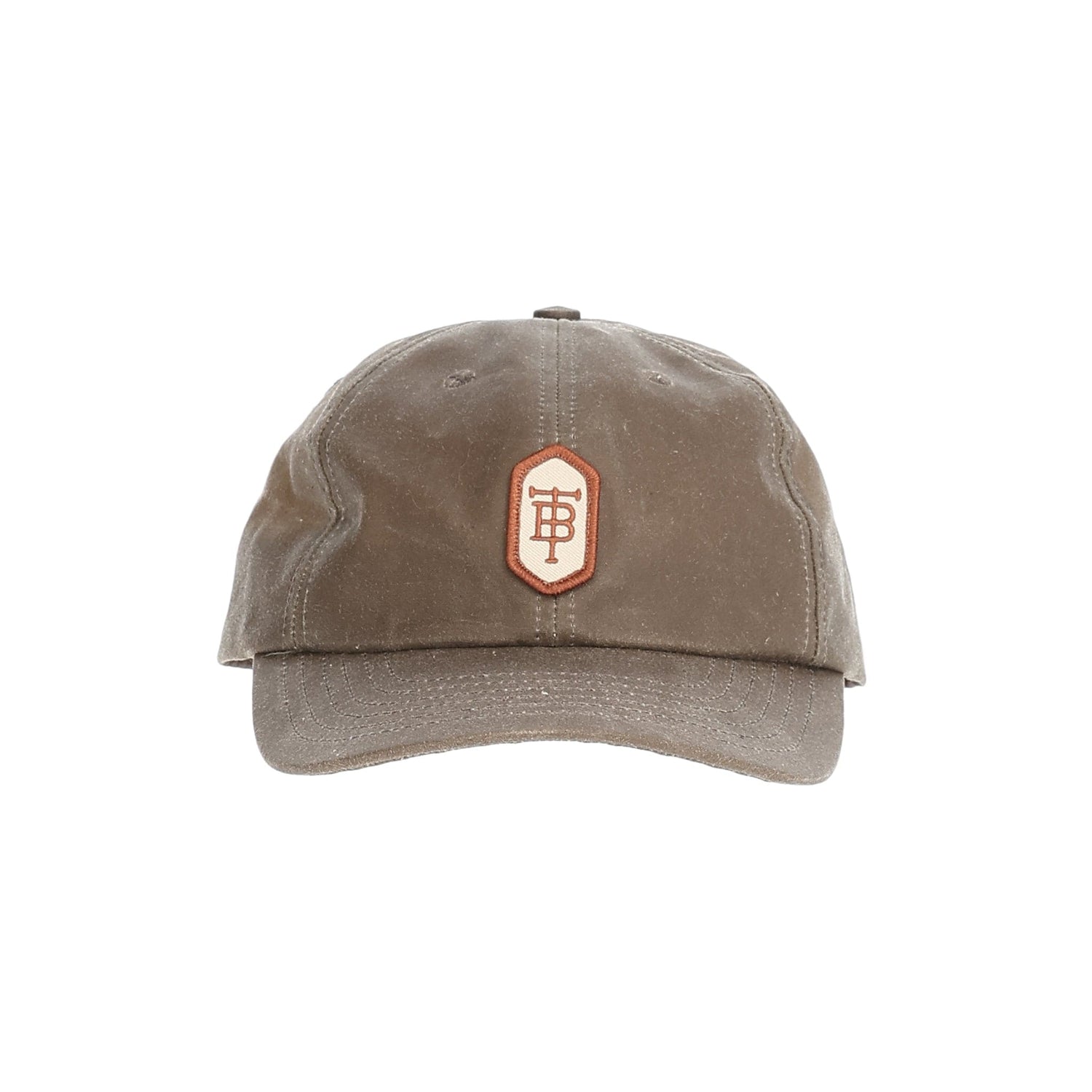 The Tom Beckbe Waxed Cotton 6-Panel Hat has an embroidered brown/beige patch with a vertical symbol on the front.