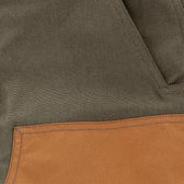 Close-up of Tom Beckbe Burwell Brush Pant in brown waxed canvas with a stitched tan pocket on the lower left side.