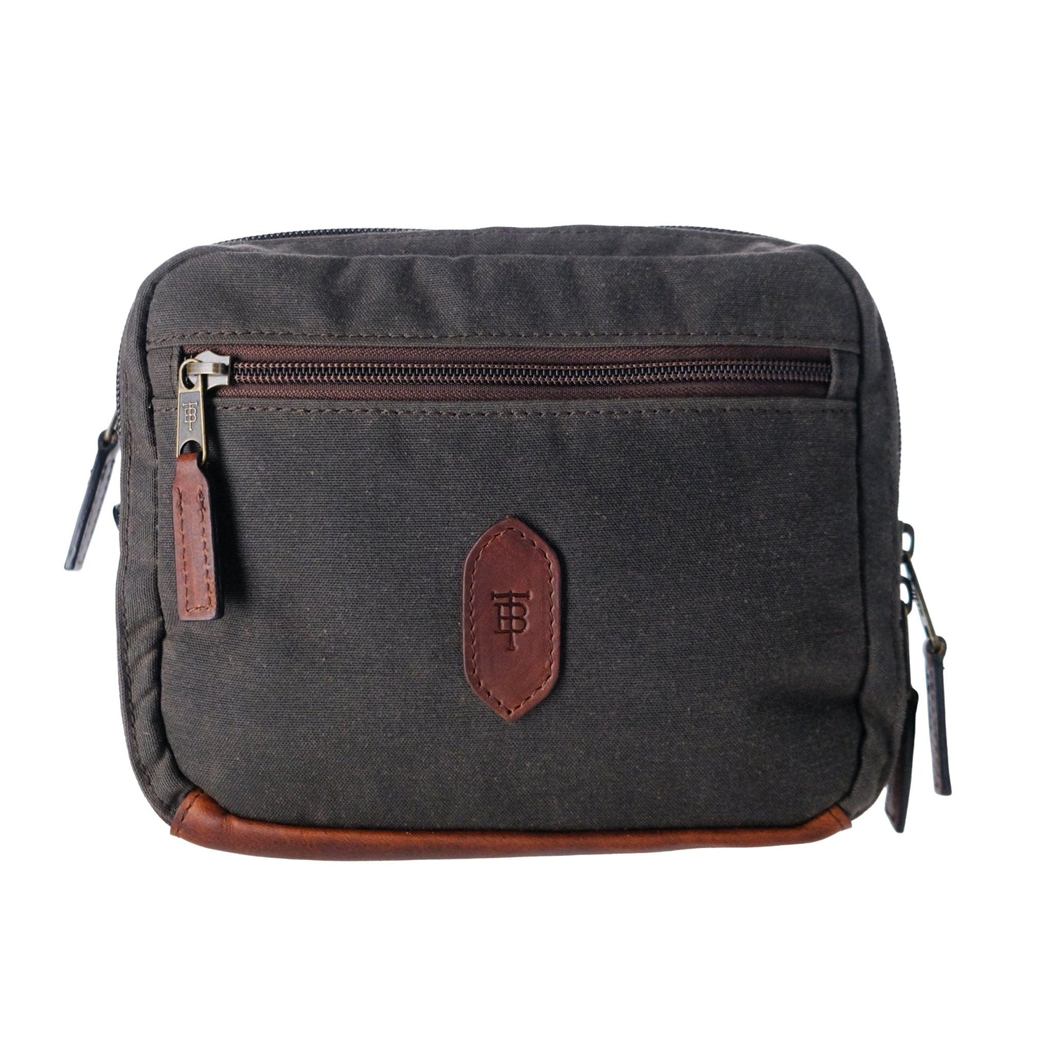 Dark gray canvas hanging toiletry bag by Tom Beckbe featuring a front zip pocket, leather accents, and branded patch.