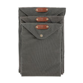 Three gray Canvas Portfolios by Tom Beckbe, weatherproof with leather tabs and snap closures, stacked together.