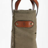 Olive green Canvas Whiskey Tote by Tom Beckbe with brown handle and brass rivets—ideal for spirits lovers.