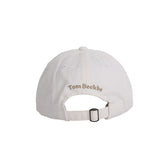 Back of Cotton Twill 6-Panel Hat - Bobwhite: Tom Beckbe embroidered above adjustable strap with metal clasp.
