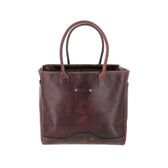 The Tom Beckbe Covington Leather Carryall Bag is a brown, full-grain tote with two handles and a structured design.