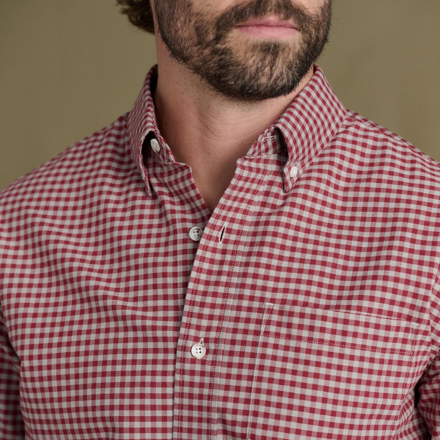 Man wearing Tom Beckbe Culver Oxford Shirt in red and white check, shown shoulders to chin with a short beard.