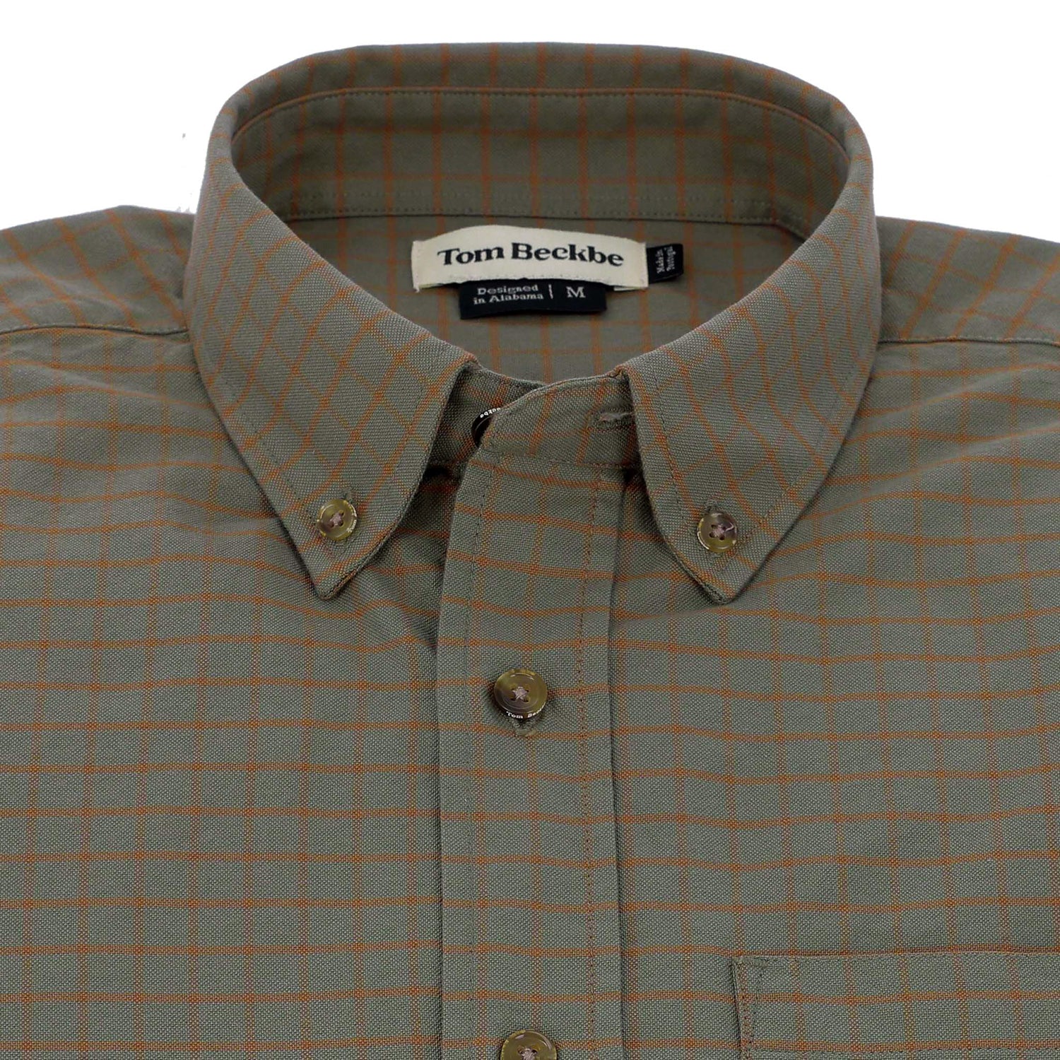 The Culver Oxford Shirt by Tom Beckbe is a green cotton shirt with an orange grid pattern and labeled collar.