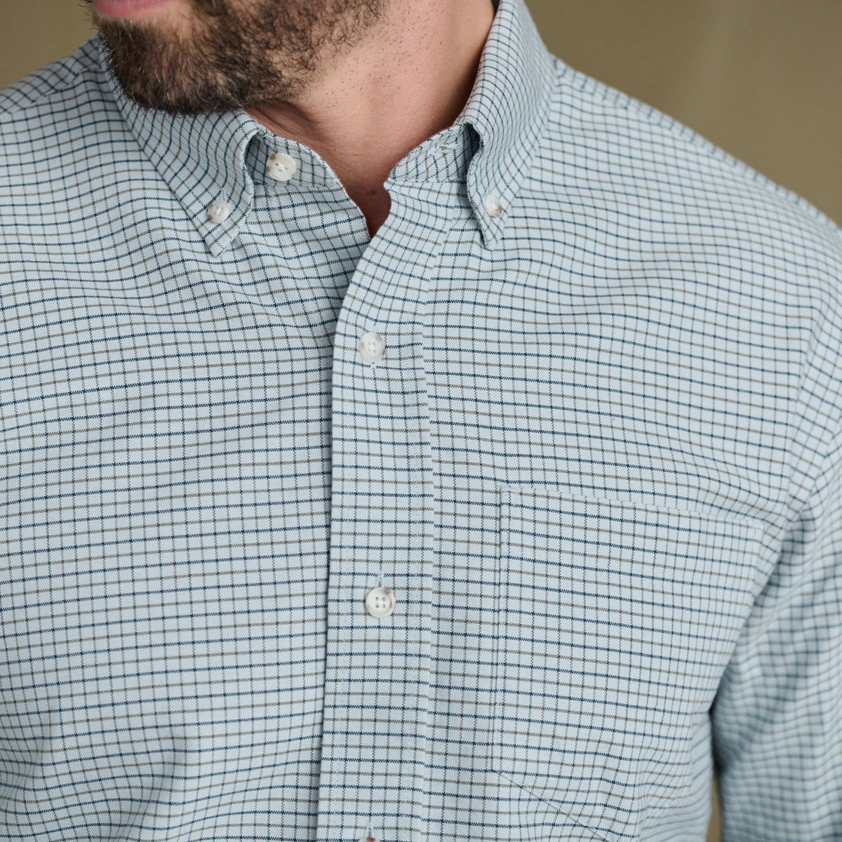 Man wearing Tom Beckbe Culver Oxford Shirt in light blue, breathable fabric with front pocket, shown neck to chest.
