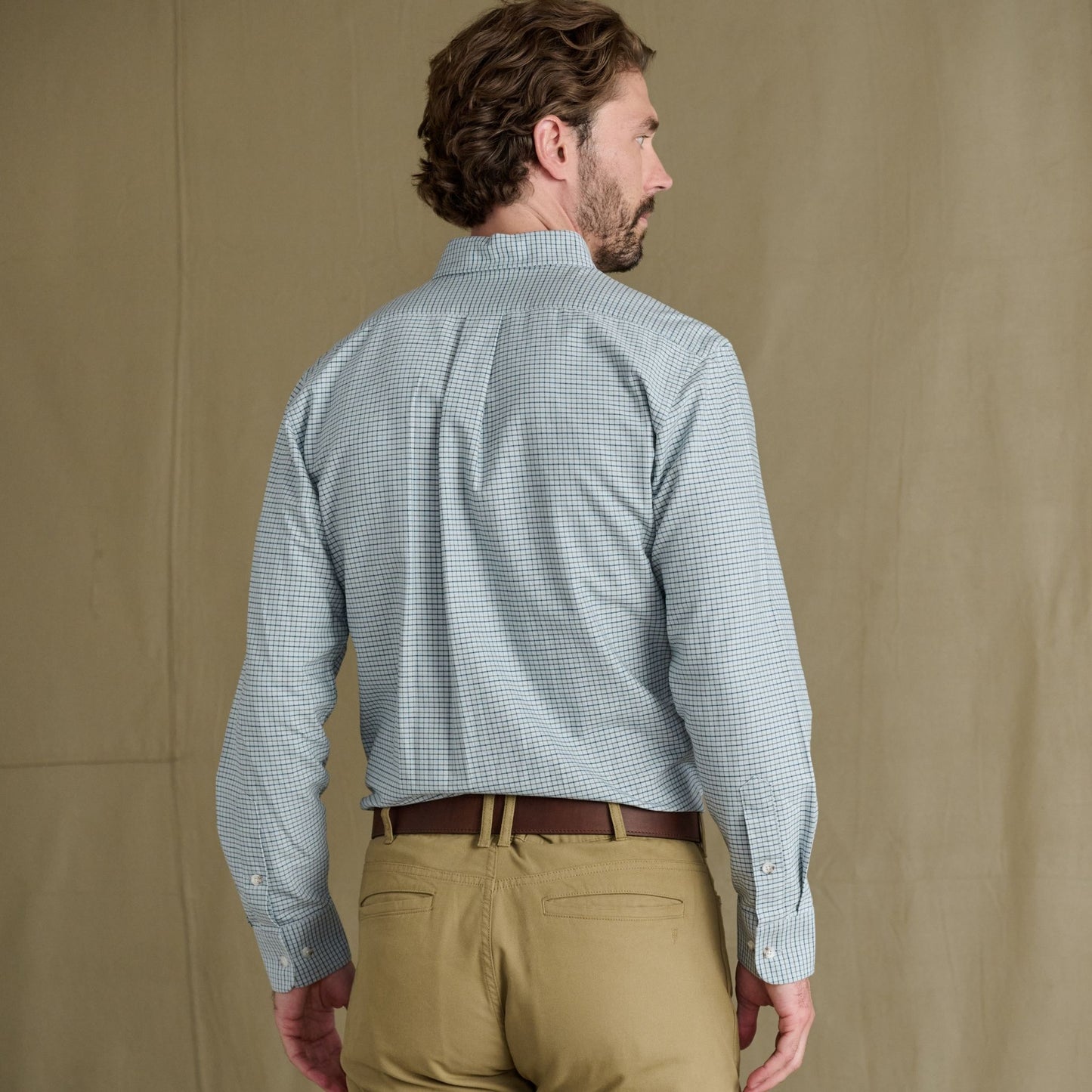 Man stands with back to camera, wearing Tom Beckbe Culver Oxford Shirt and khaki pants.