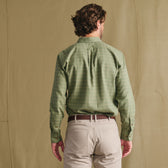 Man facing away in Tom Beckbe Dixon Brushed Cotton Twill Shirt, green check, and beige pants on a light brown backdrop.