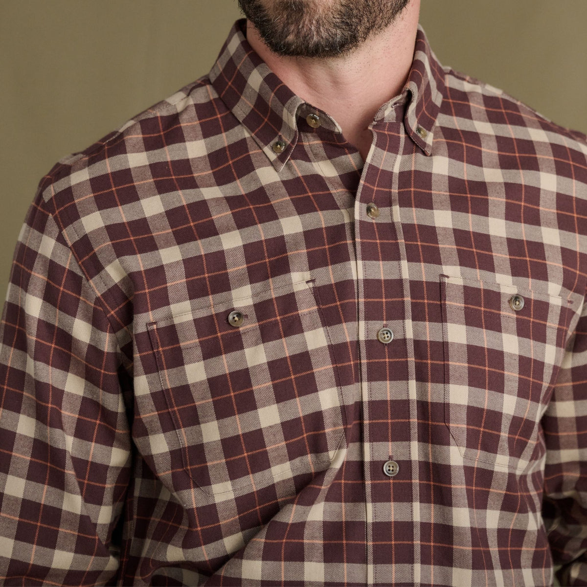 Man in a maroon and beige Tom Beckbe Dixon Brushed Cotton Twill Shirt with two chest pockets, shoulders to mid-torso.