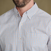 Man wearing Tom Beckbe Ensley Pinpoint Oxford Shirt in blue and orange plaid, shown from chin to chest.