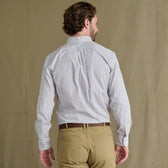 Man with short hair wears Tom Beckbe Ensley Pinpoint Oxford Shirt and khaki pants, facing away against plain background.