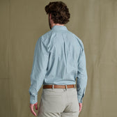 Man facing away in a Tom Beckbe Ensley Pinpoint Oxford Shirt, khaki pants, and brown belt against beige background.