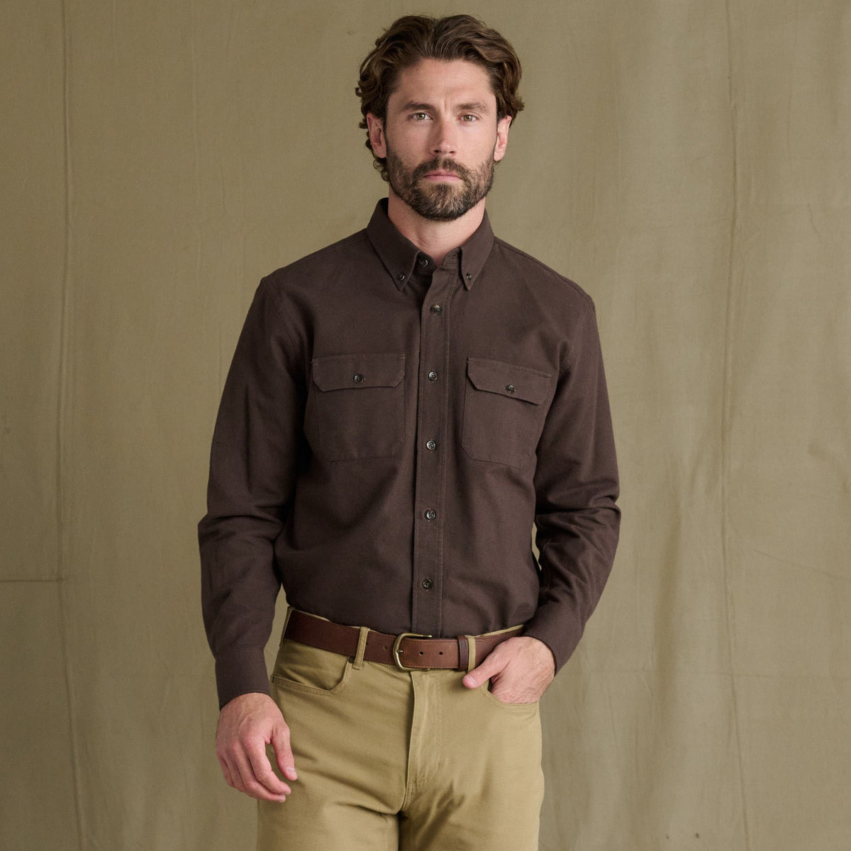 Man wears Tom Beckbe Hartwell Moleskin Shirt with tan pants, standing in front of a plain beige backdrop.