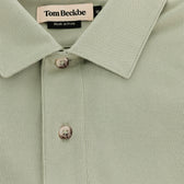 Close-up of the light green Hutton Performance Polo by Tom Beckbe, featuring two buttons on the placket.