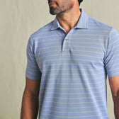 Man wearing the Tom Beckbe Hutton Performance Polo in light blue with thin white stripes, shown shoulders up.