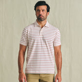 Man wearing a Tom Beckbe Hutton Performance Polo with red stripes and tan pants against a plain background.