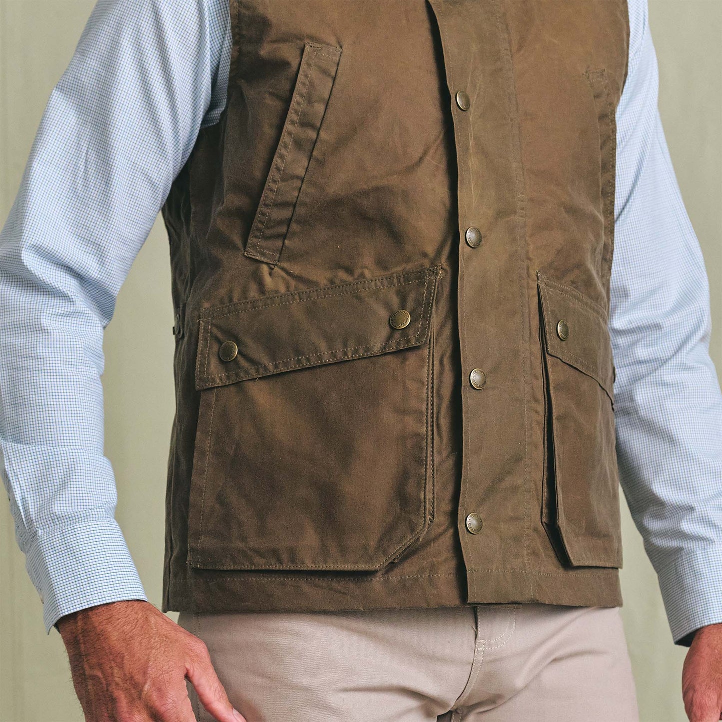 A person in a light blue dress shirt, Tom Beckbe Kinsman Vest, and light khaki pants.