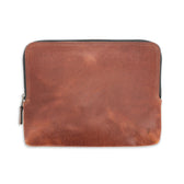 Tom Beckbe Leather Travel Pouch in brown full-grain leather with antique brass zipper, laid flat on white background.