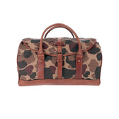 The Tom Beckbe Classic Camo Weekender Duffel Bag with brown leather trim is shown on a white background.