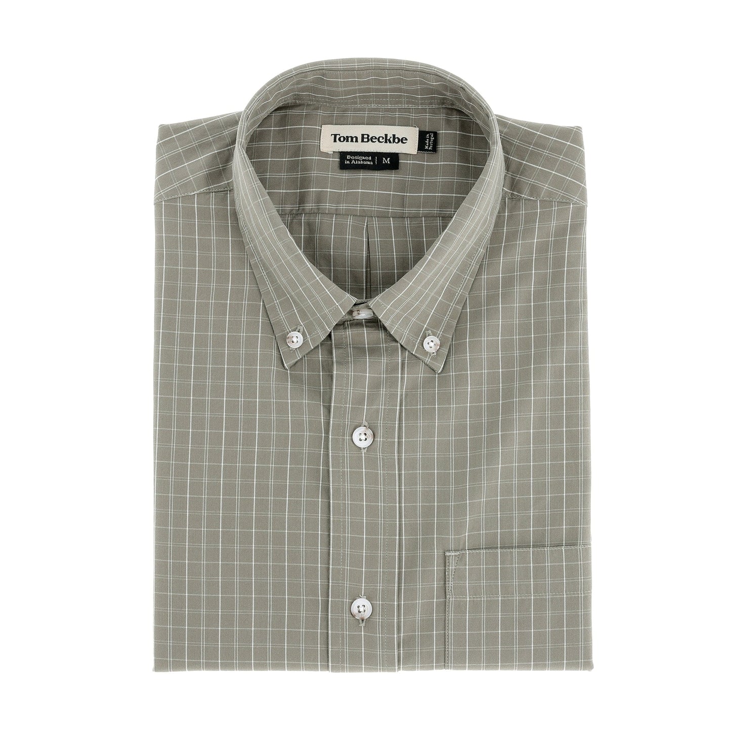 A folded moss Monroe Poplin Shirt by Tom Beckbe with front pocket and checkered pattern.