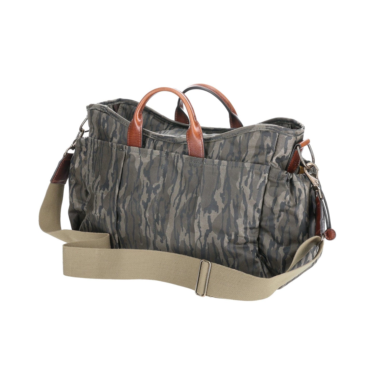 The Tom Beckbe Canvas Utility Bag in Mossy Oak Original Bottomland is shown with brown leather handles and a beige strap.