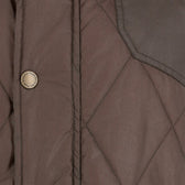 Close-up of the Tom Beckbe Paddock Quilted Jacket with brass snaps and visible stitching, perfect as a weatherproof layer.