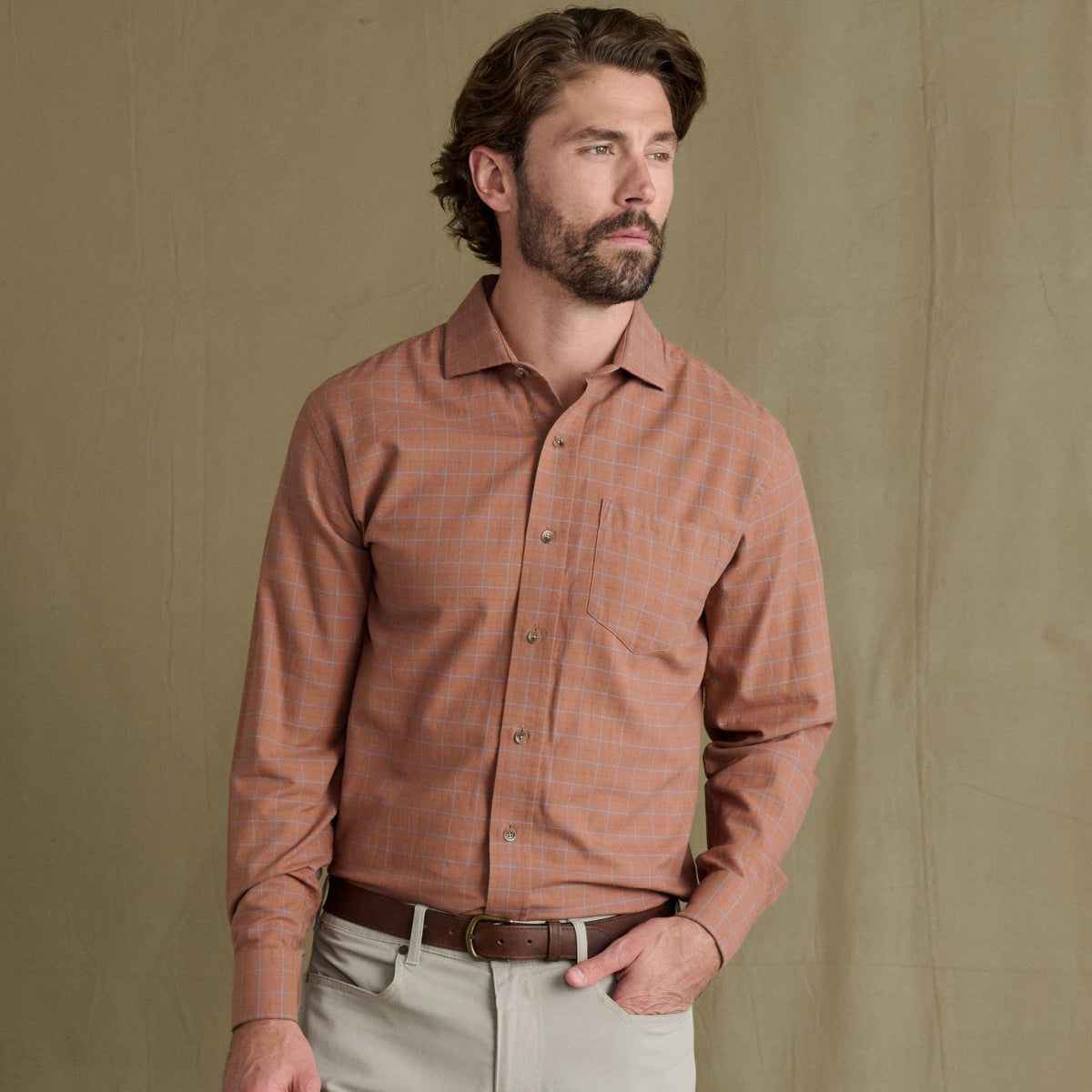 Man wears Tom Beckbe Prescott Estate Twill Shirt and beige pants, perfect for fall, against a plain tan background.