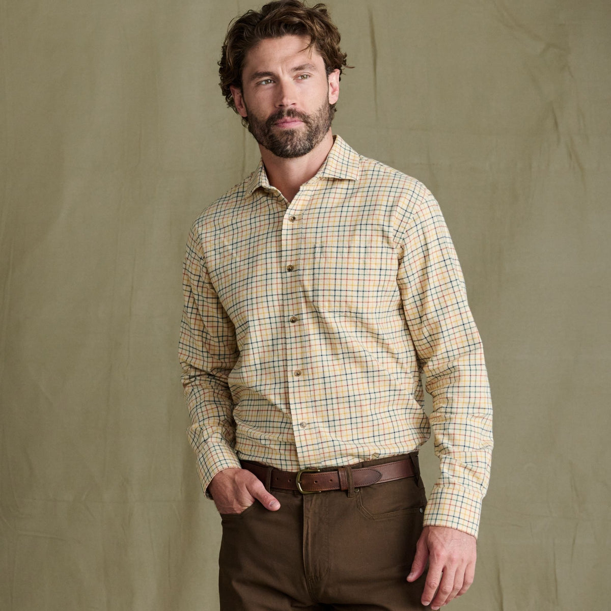 Man in Tom Beckbe Prescott Estate Twill Shirt and brown pants—ideal fall style against a plain backdrop.
