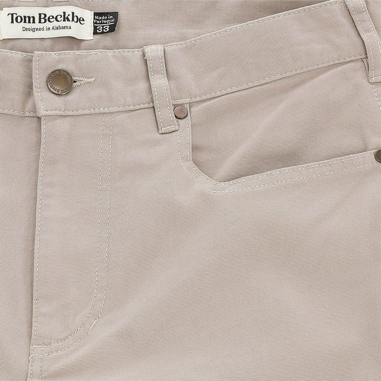 Close-up of Tom Beckbe's Reid Straight Leg Cotton Chino Pant with front pocket, belt loops, and logo label.