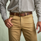 A man in a checked shirt and Tom Beckbe's Reid Straight Leg Cotton Chino Pant stands with one hand in his pocket.