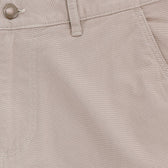 Close-up of Tom Beckbe Reid Short, light beige, mid-rise with button, belt loop, seam details, and antique brass zip fly.