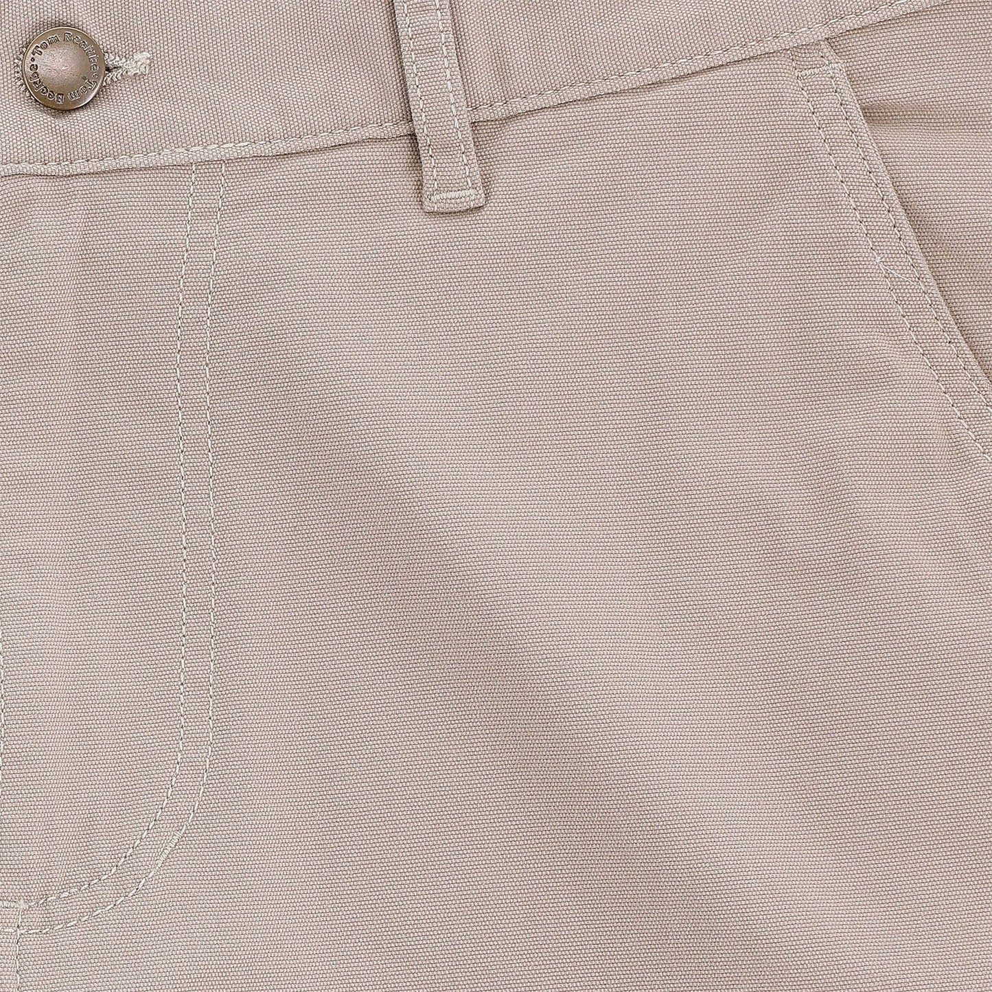 Close-up of Tom Beckbe Reid Short, light beige, mid-rise with button, belt loop, seam details, and antique brass zip fly.