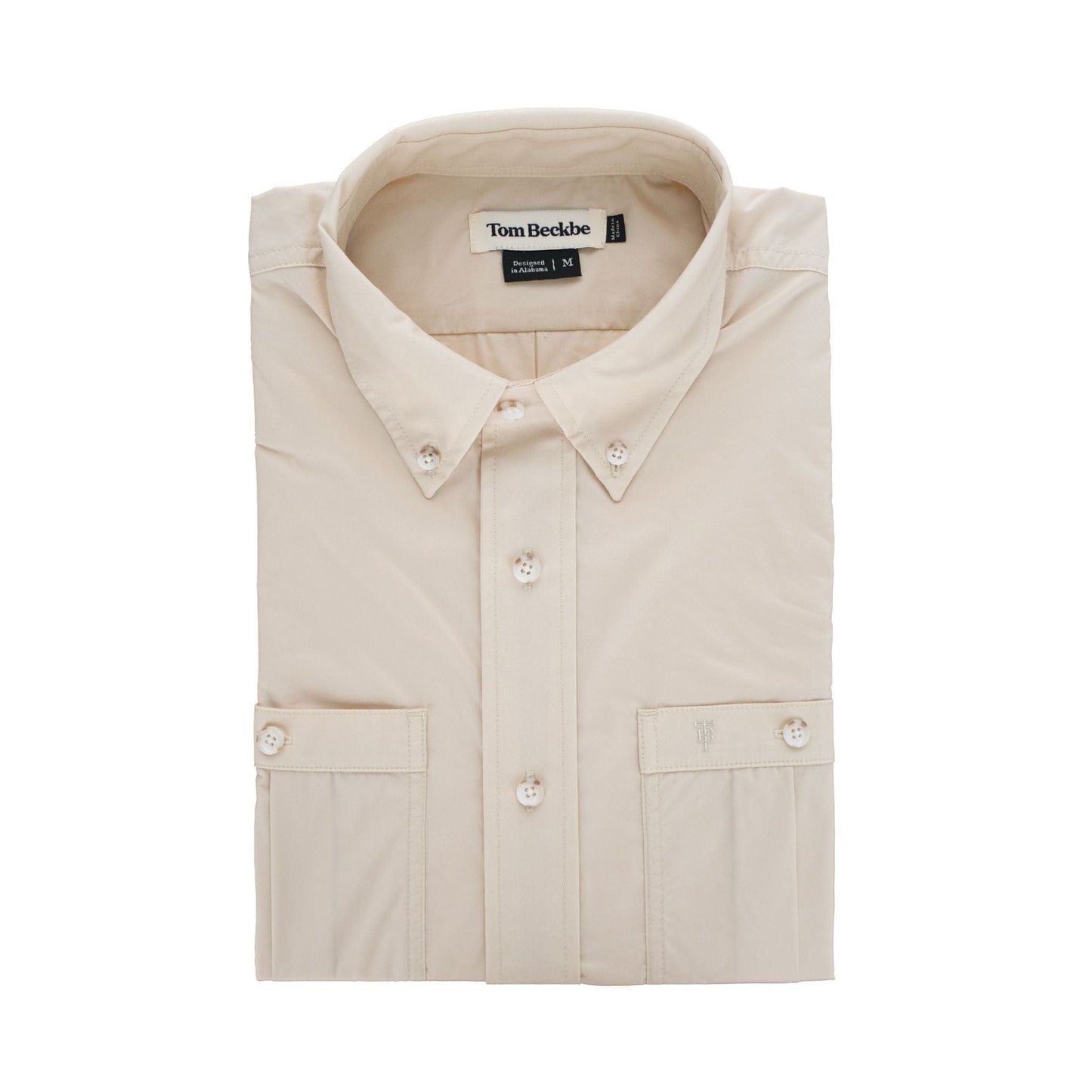 Folded Tidewater Shirt by Tom Beckbe in beige, short sleeve with UPF 30+, collar, pockets; set on a white background.