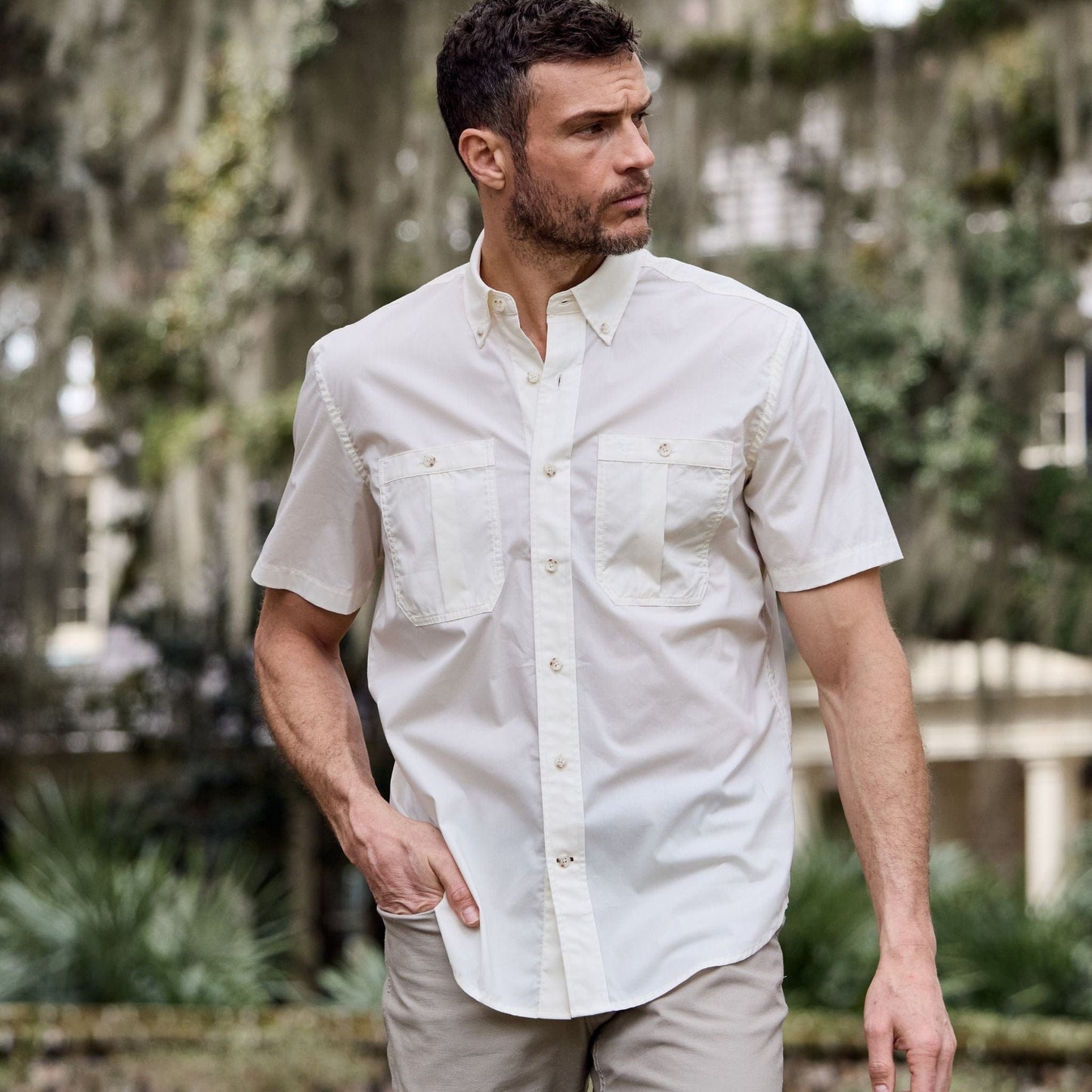 Man wearing a Tom Beckbe Tidewater Shirt in a garden, enjoying the outdoors.