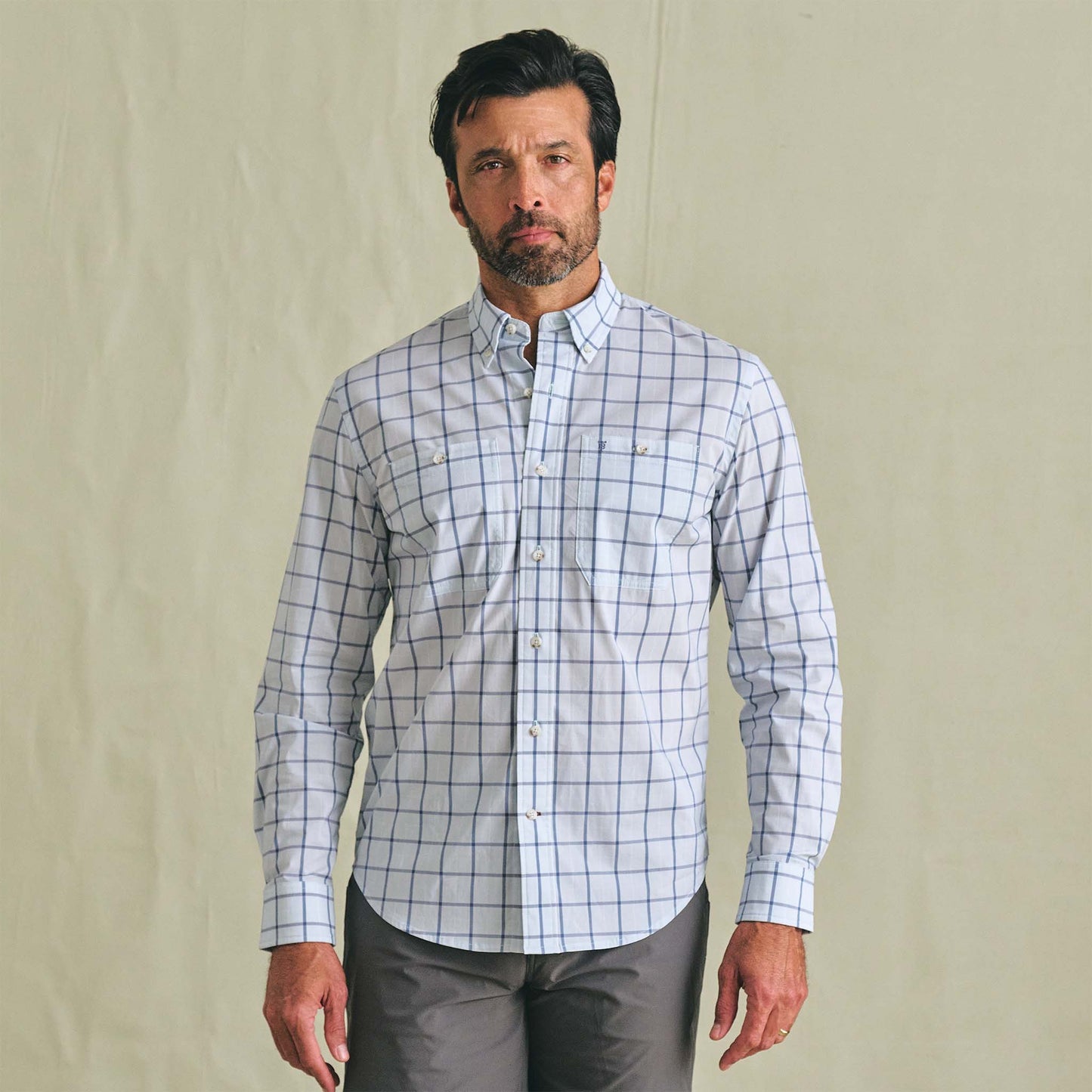 Man wearing the Tom Beckbe Tidewater Shirt, a UPF 30+ lightweight blue grid outdoor shirt, on a light background.