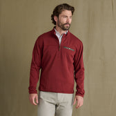 Man in a Tom Beckbe Tucker Fleece Quarter Zip and light pants stands before a plain tan backdrop.