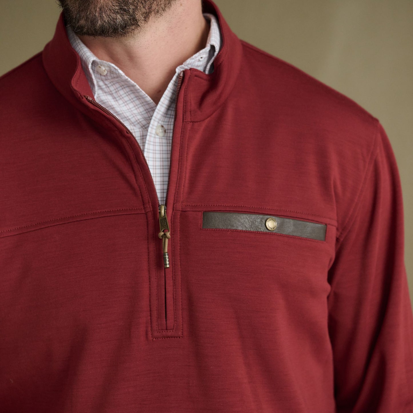 Man in Tom Beckbe Tucker Fleece Quarter Zip over a white checkered shirt, with zippered chest pocket.
