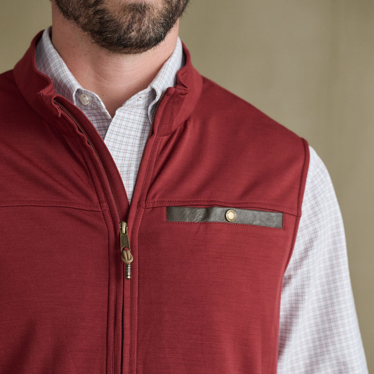 Man in Tom Beckbe Tucker Fleece Vest over light checkered shirt, shown shoulder to upper chest.