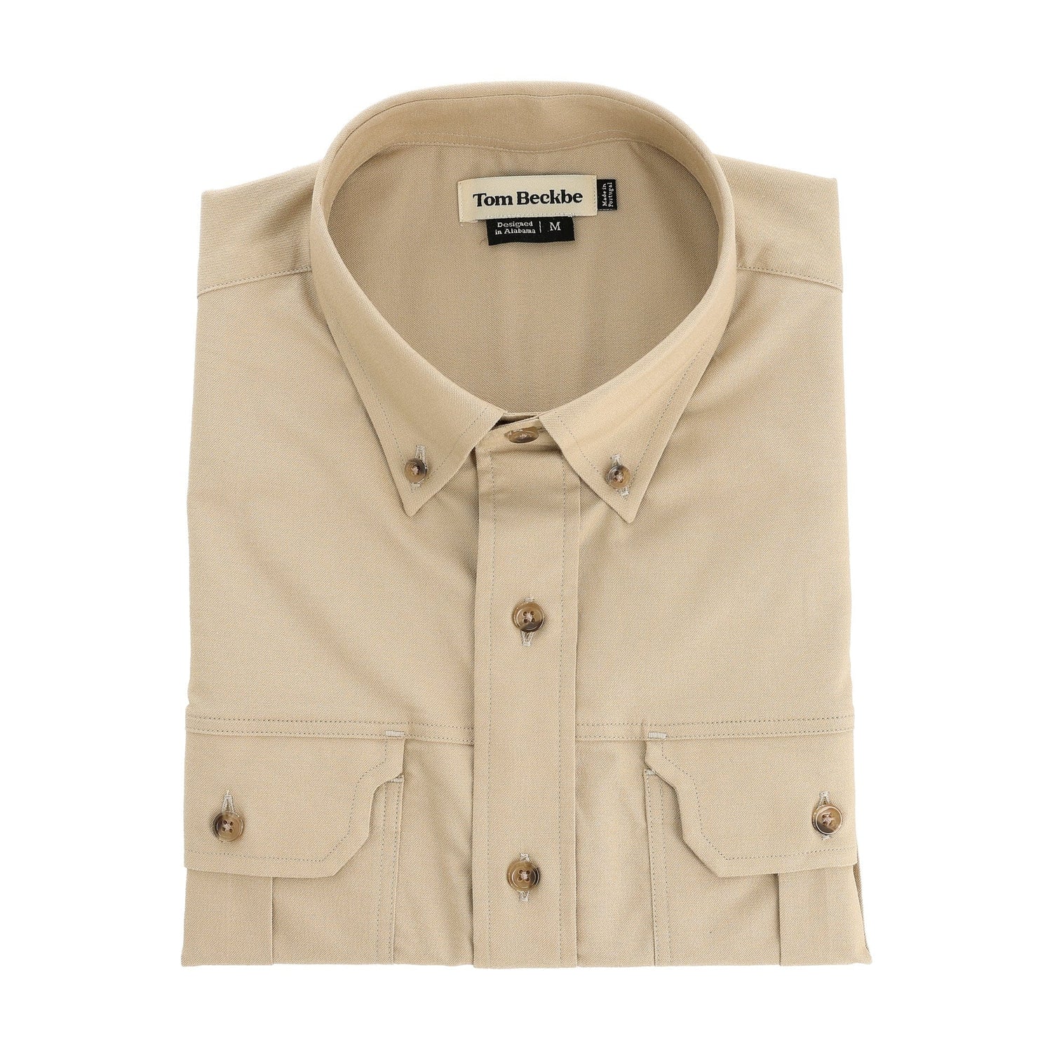 Folded beige cotton Uplander Shirt by Tom Beckbe with front pockets and a visible inside collar label.