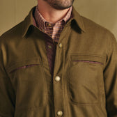 Man wears Tom Beckbe Westport Wool Overshirt in olive green over a plaid shirt, shown neck to chest.