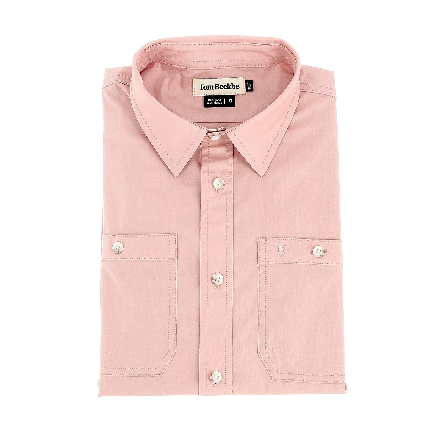 A neatly folded light pink Women's Tidewater Shirt by Tom Beckbe with long sleeves and two front pockets.