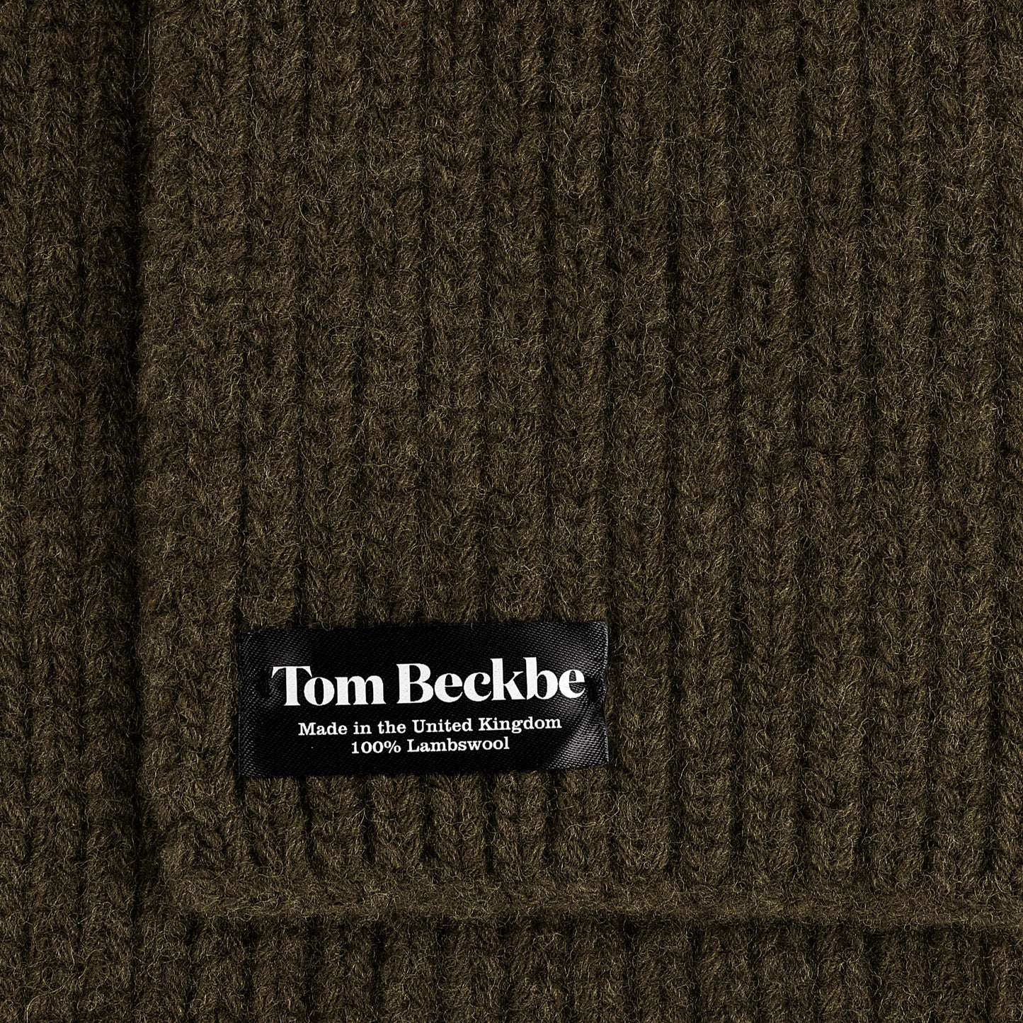 Close-up of a Tom Beckbe Wool Scarf, ribbed dark green, 100% lambswool, made in the UK.