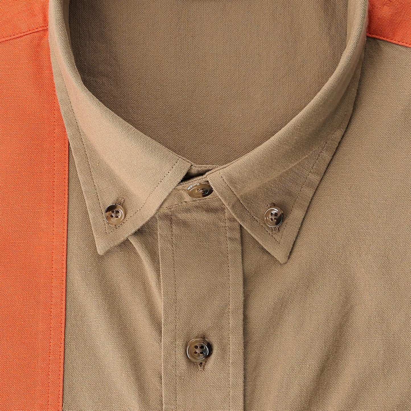 Close-up of the Perry Field Shirt collar by Tom Beckbe in tan, partially covered by an orange garment.