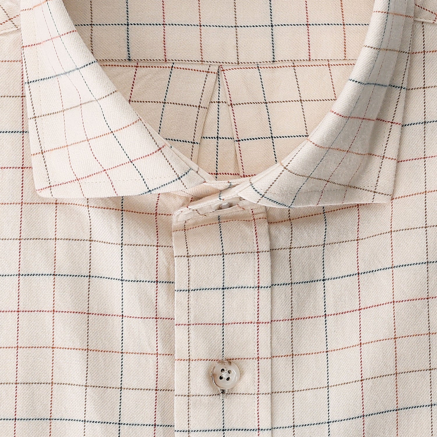 Close-up of Tom Beckbe’s Prescott Estate Twill Shirt in beige with red and blue checks, featuring a single white button.