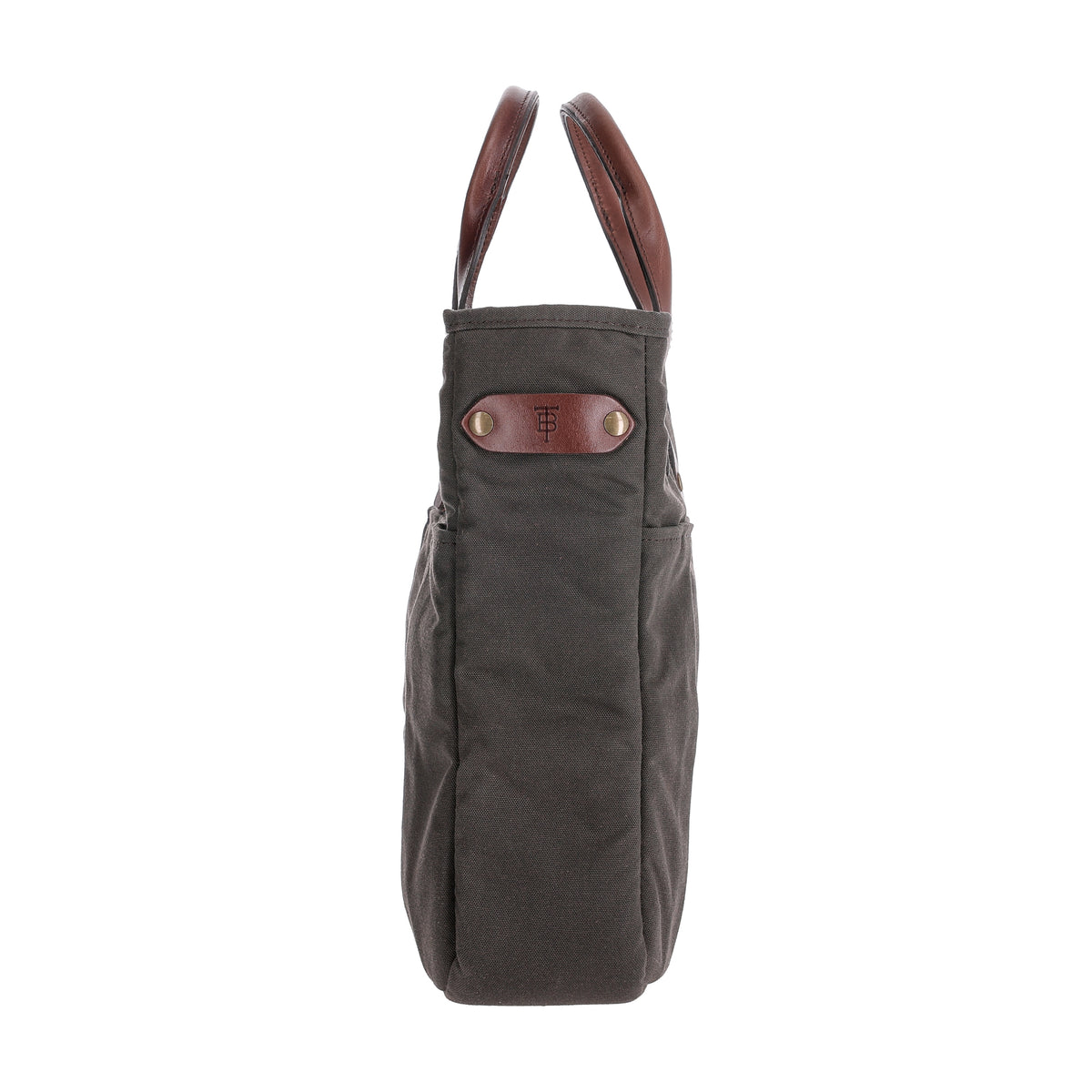 Side view of the Tom Beckbe Canvas Whiskey Tote in gray with brown handles and a patch featuring embossed initials.